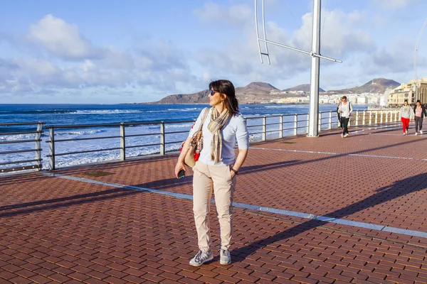 Las Palmas de Gran Canaria, İspanya, 10 Ocak 2018 üzerinde. Kış güneşi Playa de Las Canteras beach Atlantik Okyanusu kıyısında ışıklar. Çekici kadın dolgu üzerinde yürüyor