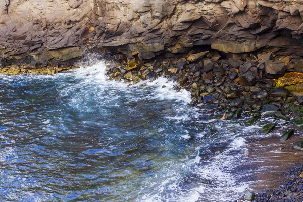 Atlantik Okyanusu kıyısında pitoresk kayaya dalgalar tarafından yıkanmış