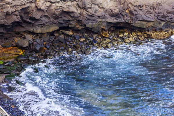 Atlantik Okyanusu kıyısında pitoresk kayaya dalgalar tarafından yıkanmış