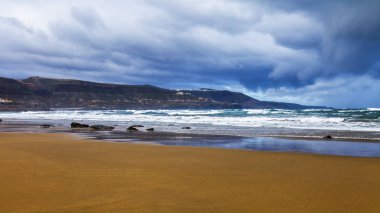 Bir sörf, bulutlu havalarda Atlantik Okyanusu kıyısında pitoresk dalgalar