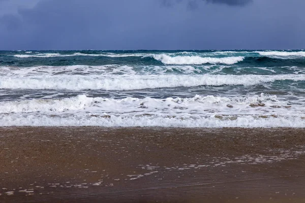 Bir sörf, bulutlu havalarda Atlantik Okyanusu kıyısında pitoresk dalgalar