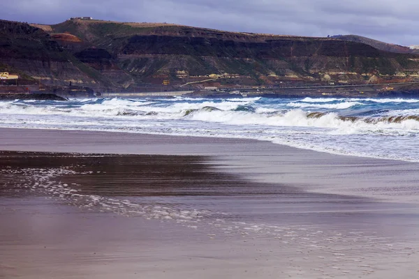 Picturesque waves of a surf at the coast of the Atlantic Ocean in cloudy weather