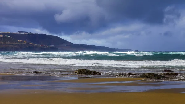 Picturesque waves of a surf at the coast of the Atlantic Ocean in cloudy weather