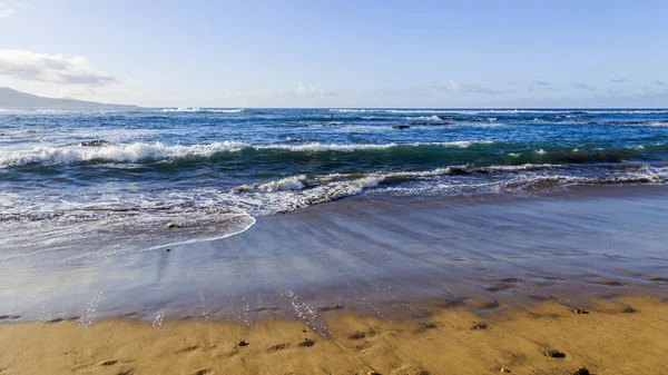 Picturesque waves of a surf at the coast of the Atlantic Ocean in cloudy weather