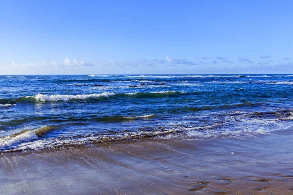 Bir sörf, bulutlu havalarda Atlantik Okyanusu kıyısında pitoresk dalgalar