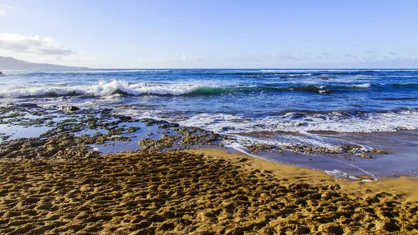Bir sörf, bulutlu havalarda Atlantik Okyanusu kıyısında pitoresk dalgalar