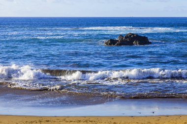 Bir sörf, bulutlu havalarda Atlantik Okyanusu kıyısında pitoresk dalgalar