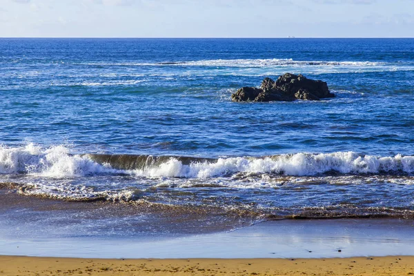 Bir sörf, bulutlu havalarda Atlantik Okyanusu kıyısında pitoresk dalgalar