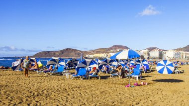 Las Palmas de Gran Canaria, İspanya, 10 Ocak 2018 üzerinde. Kış güneşi Playa de Las Canteras beach Atlantik Okyanusu kıyısında ışıklar. İnsanlar biraz dinlen ve yakın bir su kenarı güneşlenmek