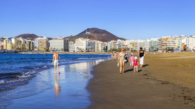 Las Palmas de Gran Canaria, İspanya, 10 Ocak 2018 üzerinde. Kış güneşi Playa de Las Canteras beach Atlantik Okyanusu kıyısında ışıklar. İnsanlar yakın bir su kenarı yürüyüş