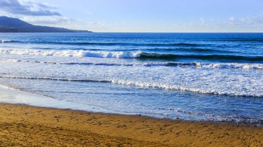 Bulutlu havalarda Atlantik Okyanusu kıyısında, pitoresk sörf
