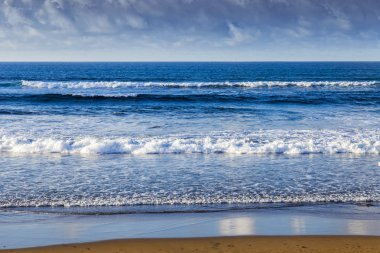 Bulutlu havalarda Atlantik Okyanusu kıyısında, pitoresk sörf