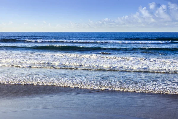 Picturesque surf at the coast of the Atlantic Ocean in cloudy weather