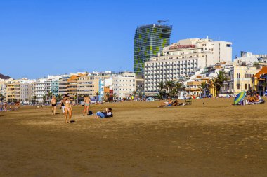 Las Palmas de Gran Canaria, İspanya, 10 Ocak 2018 üzerinde. Kış güneşi Playa de Las Canteras beach Atlantik Okyanusu kıyısında ışıklar. İnsanlar biraz dinlen ve yakın bir su kenarı güneşlenmek