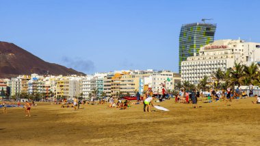 Las Palmas de Gran Canaria, İspanya, 10 Ocak 2018 üzerinde. Kış güneşi Playa de Las Canteras beach Atlantik Okyanusu kıyısında ışıklar. İnsanlar biraz dinlen ve yakın bir su kenarı güneşlenmek