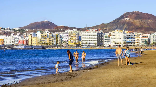 Las Palmas de Gran Canaria, İspanya, 10 Ocak 2018 üzerinde. Kış güneşi Playa de Las Canteras beach Atlantik Okyanusu kıyısında ışıklar. İnsanlar biraz dinlen ve yakın bir su kenarı güneşlenmek