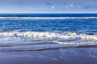 Bulutlu havalarda Atlantik Okyanusu kıyısında, pitoresk sörf