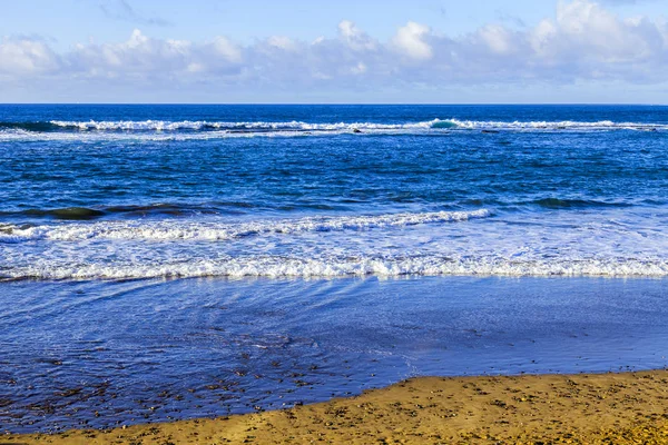 Picturesque surf at the coast of the Atlantic Ocean in cloudy weather