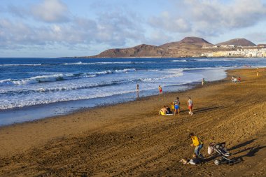 Las Palmas de Gran Canaria, İspanya, 10 Ocak 2018 üzerinde. Kış güneşi Playa de Las Canteras beach Atlantik Okyanusu kıyısında ışıklar. İnsanlar biraz dinlen ve bir su kenarı güneşlenmek