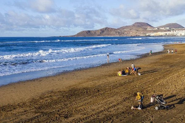 Las Palmas de Gran Canaria, İspanya, 10 Ocak 2018 üzerinde. Kış güneşi Playa de Las Canteras beach Atlantik Okyanusu kıyısında ışıklar. İnsanlar biraz dinlen ve bir su kenarı güneşlenmek