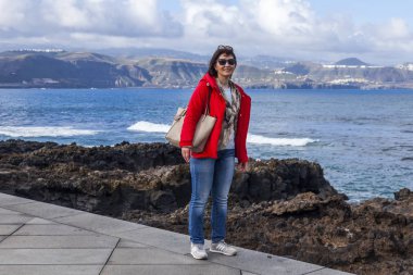 Las Palmas de Gran Canaria, İspanya, 10 Ocak 2018 üzerinde. Kış okyanus dalgalarının bilir. Kadın bir sörf çevre satır banka üzerinde yürüyor