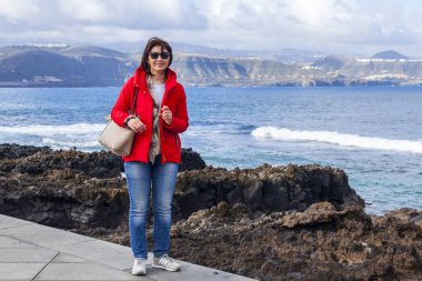 Las Palmas de Gran Canaria, İspanya, 10 Ocak 2018 üzerinde. Kış okyanus dalgalarının bilir. Kadın bir sörf çevre satır banka üzerinde yürüyor