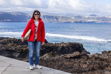 Las Palmas de Gran Canaria, İspanya, 10 Ocak 2018 üzerinde. Kış okyanus dalgalarının bilir. Kadın bir sörf çevre satır banka üzerinde yürüyor