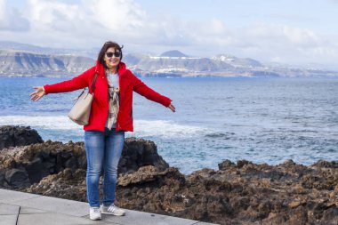 Las Palmas de Gran Canaria, İspanya, 10 Ocak 2018 üzerinde. Kış okyanus dalgalarının bilir. Kadın bir sörf çevre satır banka üzerinde yürüyor