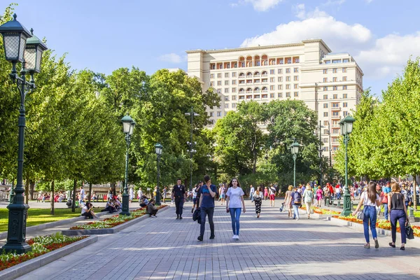 stock image Moscow, Russia, on June 25, 2018. People go along the beautiful avenue in Aleksandrovsk to a garden. The Moscow hotel is visible in the distance