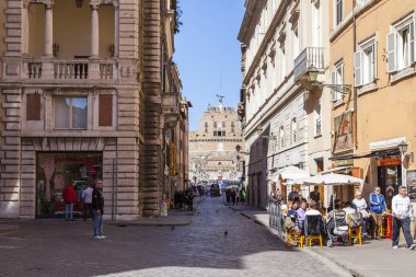 11 Mart 2017 tarihinde, Roma, İtalya. İnsanlar şehrin tarihi kesiminde güzel cadde boyunca gidin. Castel Sant Angelo uzaktan görülür