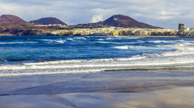 Las Palmas de Gran Canaria, İspanya, 10 Ocak 2018 üzerinde. Kış güneşi Playa de Las Canteras beach Atlantik Okyanusu kıyısında ışıklar. Uzaktan güzel dolgu