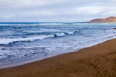 Bulutlu havalarda Atlantik Okyanusu kıyısında, pitoresk sörf