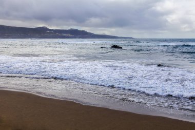 Bulutlu havalarda Atlantik Okyanusu kıyısında, pitoresk sörf
