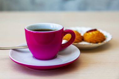 Espresso kahve parlak pembe porselen fincan ve bir tabak kurabiye