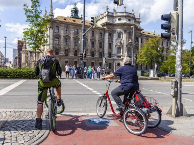 Münih, Almanya, üzerinde 16 Ağustos 2018. Tipik şehir sokak. Bisikletçiler yaya geçidi durduruldu