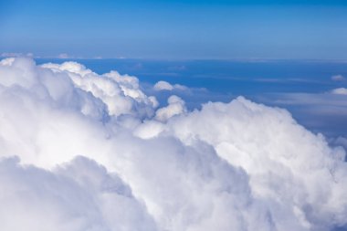 Gökyüzü ve pitoresk bulutlar büyük yükseklikte uçan uçak penceresinden görünümü