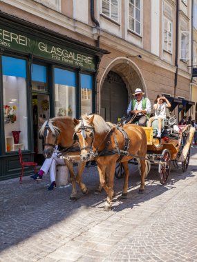 17 Ağustos 2018 üzerinde Salzburg, Avusturya. Eski şehrin pitoresk sokakta. Turistler tarafından at araç go