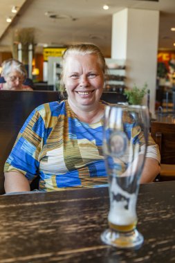 Münih, Almanya, Tarih 22 Ağustos 2018. Neşeli yaşlı kadın ile bir bardak bira içinde psikopat bir geleneksel Münih keş