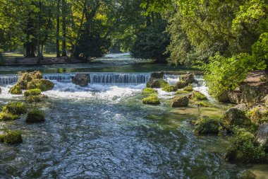 Münih, Almanya, Tarih 22 Ağustos 2018. İngiliz Bahçesi - şehir parklarından biridir. Ağaçları arasında güzel bir yapay akışı