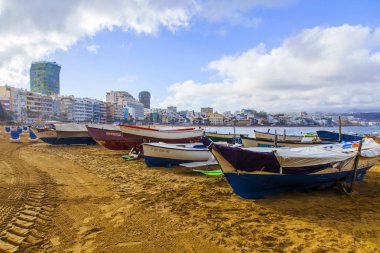Las Palmas de Gran Canaria, İspanya, 10 Ocak 2018 üzerinde. Playa de Las Canteras Beach Atlantik Okyanusu ve uzaktan güzel dolgu kıyısında bir kış manzara. Balıkçı tekneleri kum üzerinde