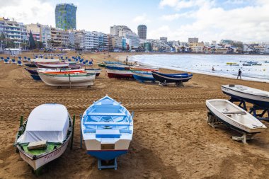 Las Palmas de Gran Canaria, İspanya, 10 Ocak 2018 üzerinde. Playa de Las Canteras Beach Atlantik Okyanusu ve uzaktan güzel dolgu kıyısında bir kış manzara. Balıkçı tekneleri kum üzerinde