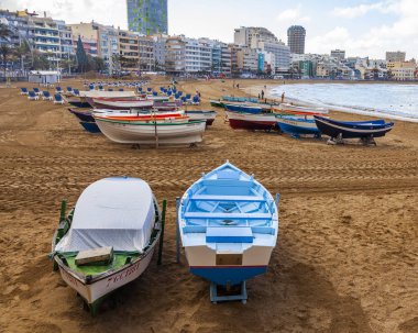 Las Palmas de Gran Canaria, İspanya, 10 Ocak 2018 üzerinde. Playa de Las Canteras Beach Atlantik Okyanusu ve uzaktan güzel dolgu kıyısında bir kış manzara. Balıkçı tekneleri kum üzerinde