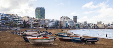Las Palmas de Gran Canaria, İspanya, 10 Ocak 2018 üzerinde. Playa de Las Canteras Beach Atlantik Okyanusu ve uzaktan güzel dolgu kıyısında bir kış manzara. Balıkçı tekneleri kum üzerinde