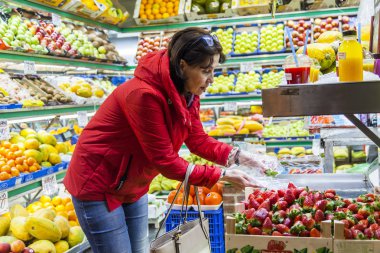 Las Palmas de Gran Canaria, İspanya, 6 Ocak 2018 üzerinde. Kadın tarihi çiftçi Mercado de Vegueta pazar içinde çilek satın alır.