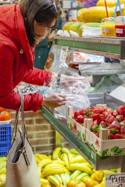 Las Palmas de Gran Canaria, İspanya, 6 Ocak 2018 üzerinde. Kadın tarihi çiftçi Mercado de Vegueta pazar içinde çilek satın alır.