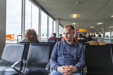 Amsterdam, Hollanda, üzerinde 23 Ekim 2018. Yolcular uçuş'Uluslararası Havaalanı Schiphol gidiş salonunda bekliyoruz