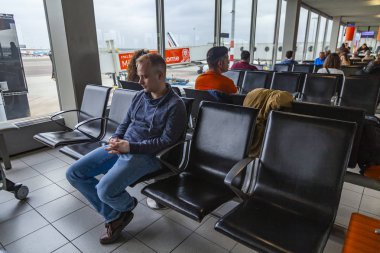 Amsterdam, Hollanda, üzerinde 23 Ekim 2018. Yolcular uçuş'Uluslararası Havaalanı Schiphol gidiş salonunda bekliyoruz