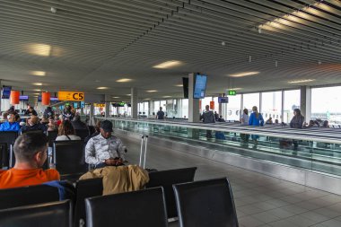 Amsterdam, Hollanda, üzerinde 23 Ekim 2018. Yolcular uçuş'Uluslararası Havaalanı Schiphol gidiş salonunda bekliyoruz