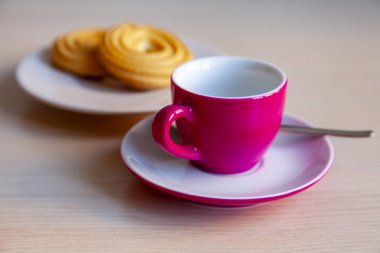 Espresso kahve parlak pembe porselen fincan ve bir tabak kurabiye