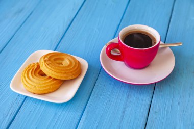 Espresso kahve parlak pembe porselen fincan ve bir tabak kurabiye